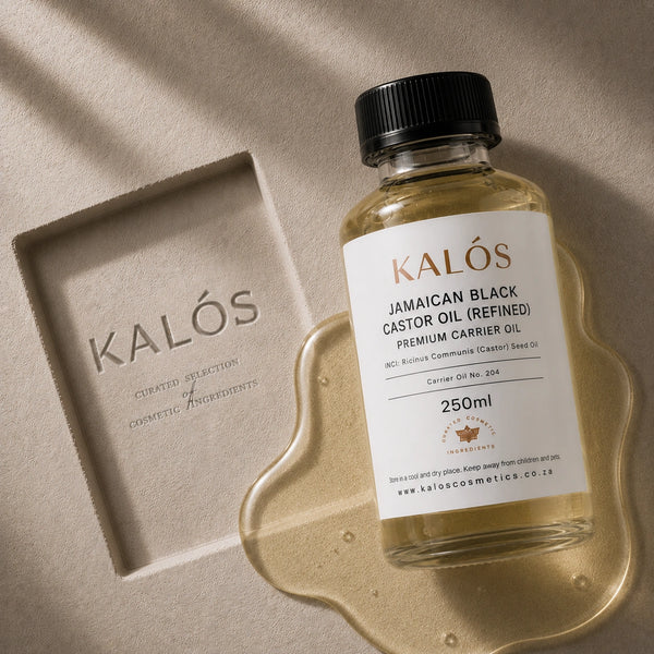 Bottle of Kalós Jamaican Black Castor Oil on a textured surface with 'Kalós' branding.
