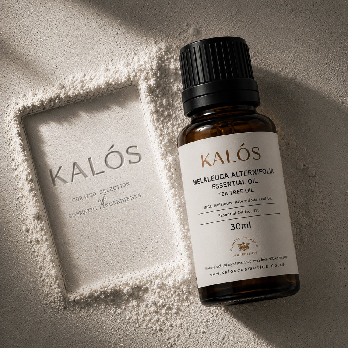 Bottle of Kalós essential oil on a textured surface with a branded box.